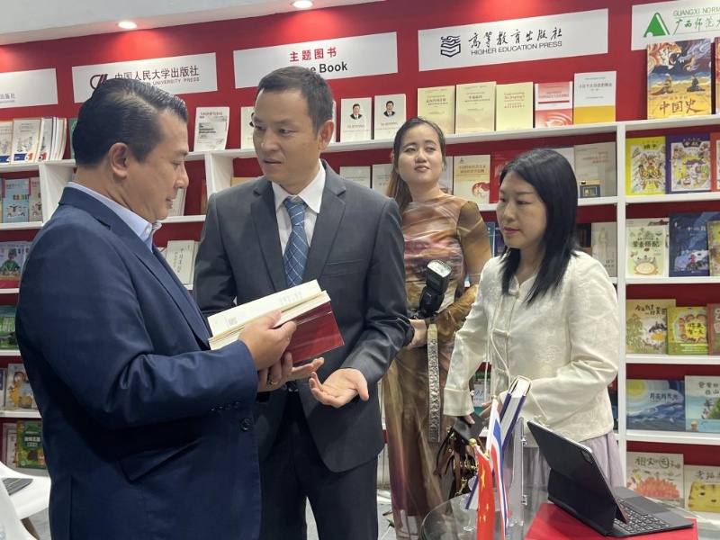 泰國書(shū)商和出版商協(xié)會(huì )主席蘇維奇（左一）在翻閱《近鏡頭：溫暖的瞬間》。（盧雯 攝）jpg_副本.jpg