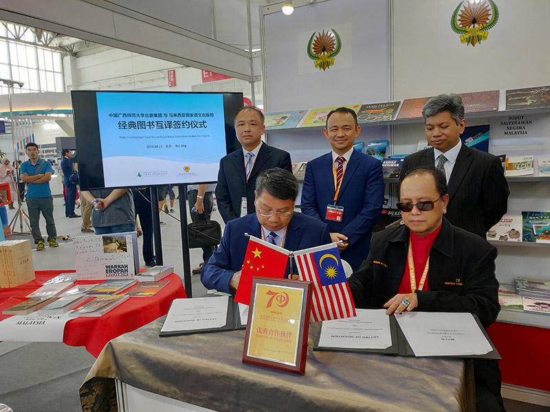 廣西師范大學(xué)出版社集團黨委書(shū)記、董事長(cháng)張藝兵（左前一）與馬來(lái)西亞國家語(yǔ)文出版局理事長(cháng)Datuk Abang Sallehuddin Abang Shokeran簽訂合約（陳子鋒攝）.jpg