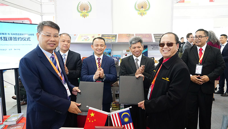 廣西師范大學(xué)出版社集團黨委書(shū)記、董事長(cháng)張藝兵（左前一）與馬來(lái)西亞國家語(yǔ)文出版局理事長(cháng)Datuk Abang Sallehuddin Abang Shokeran交換簽約文件（陳子鋒攝）.jpg