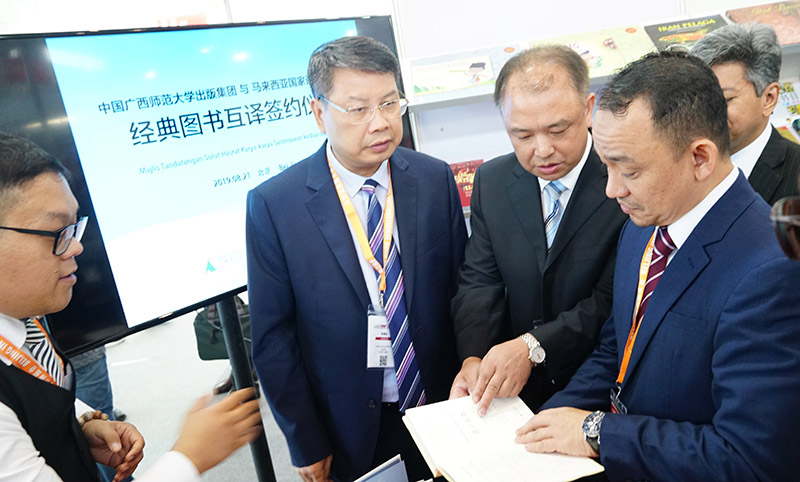 廣西師范大學(xué)黨委副書(shū)記趙鐵向馬來(lái)西亞教育部部長(cháng)Dr. Maszlee Malik（右一）介紹廣西師范大學(xué)出版社集團圖書(shū)（陳子鋒攝）.jpg